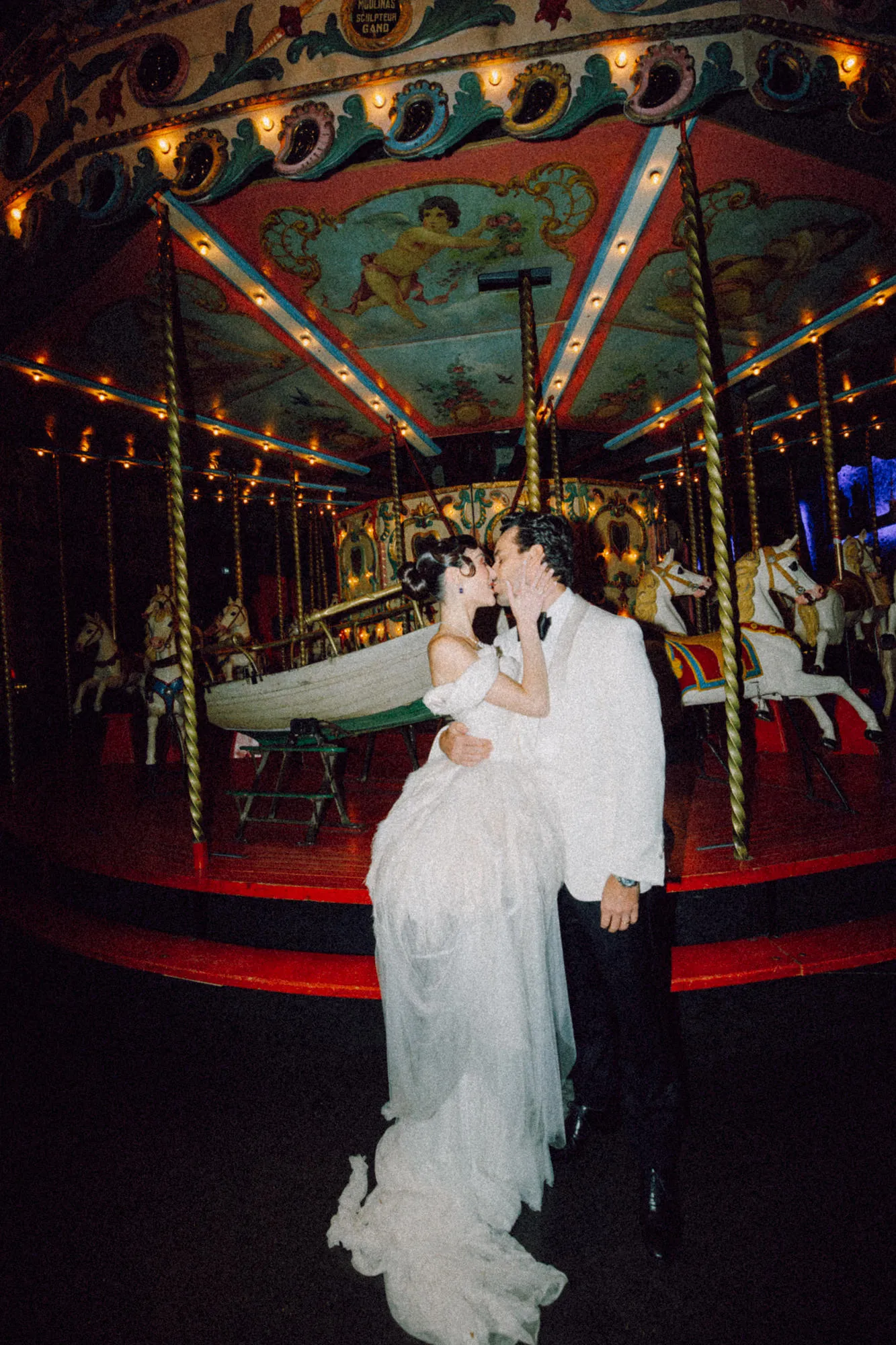 Casal se beijando em frente a um carrossel